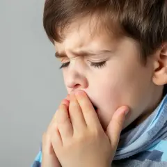 Chłopiec z zakrytymi ustami i nosem, zaciśniętymi powiekami. Czy to objawy RSV?
