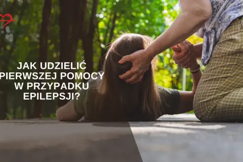 Starsza osoba pomaga osobie leżącej na ziemi, udzielając pierwszej pomocy w przypadku padaczki.