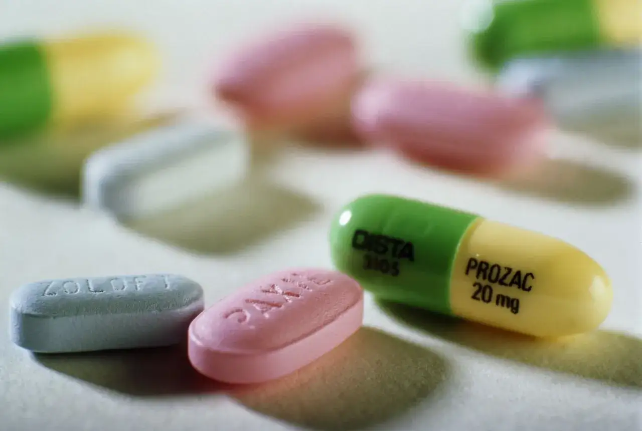 Kolorowe tabletki i kapsułki, w tym zielono-żółta kapsułka z napisem PROZAC 20 mg, mogą pomóc w walce z depresją.